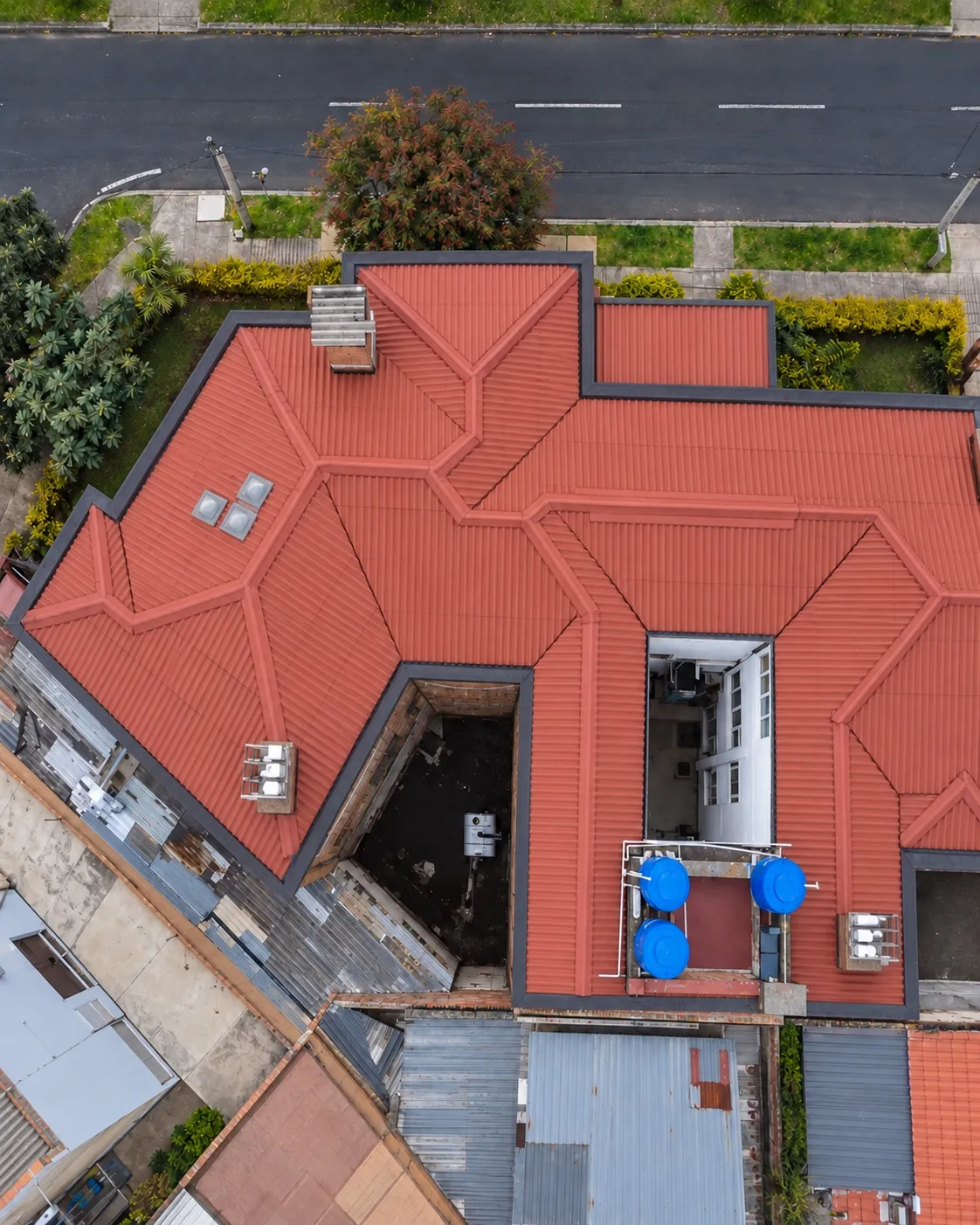 La misma cubierta vista desde el aire, recuperada e impermeabilizada con acabado rojo y cumbreras renovadas