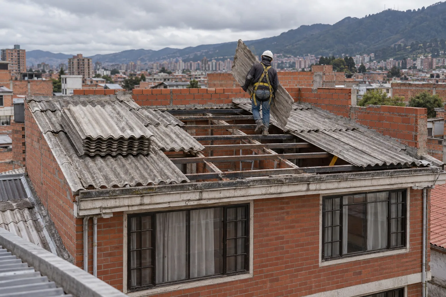 Operario retirando la teja de fibrocemento de una casa para levantar un piso más