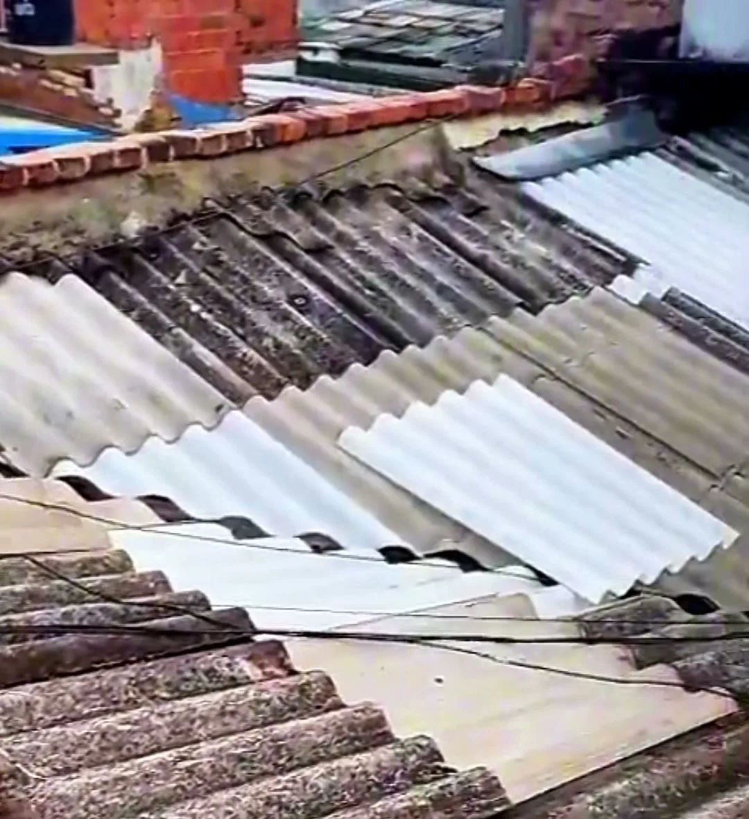 Retiro de teja vieja de fibrocemento en la cubierta de una casa, con la estructura a la vista
